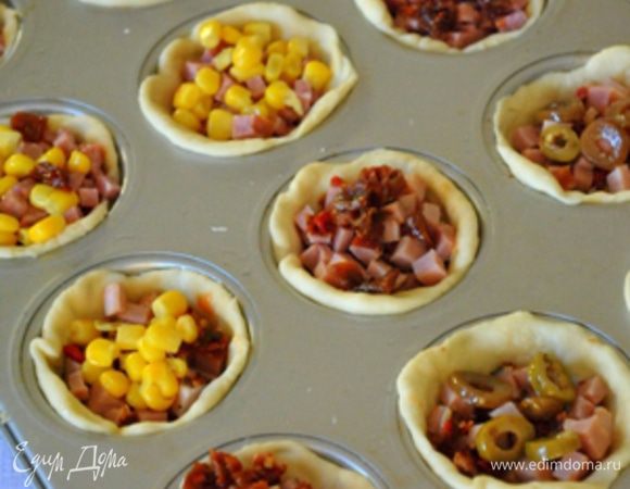 На дно тестяных формочек положить щедро томатный соус, сверху начинку.