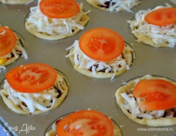 Выложить горкой сыр и сверху положить тонкие кружочки помидоров