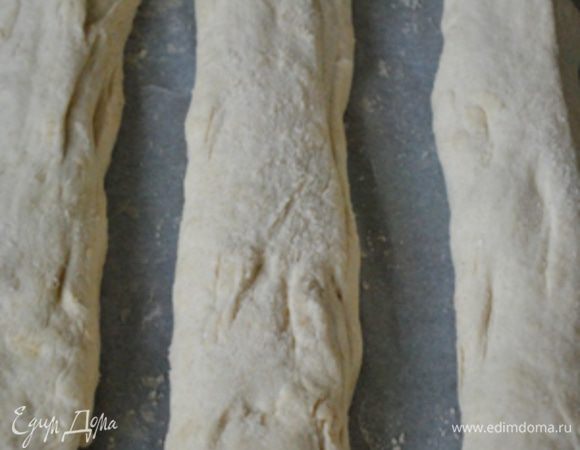 Выложить тесто в смазанную маслом миску и оставить для подъема на час-полтора (должно увеличиться вдвое).
Бумагу для выпечки посыпать кукурузной мукой.
Готовое тесто обмять, разделить на 3 части, сформировать багеты, положить на подготовленную бумагу,