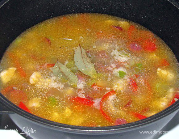 Влить куринный бульон, положить сверху лавровый лист. На сильном огне довести джамбалайю до кипения, после чего уменьшить огонь, накрыть крышкой и готовить 20 минут или меньше, до готовности риса.