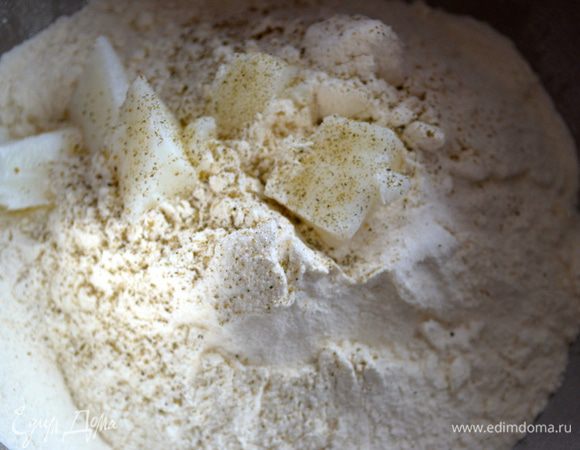 Для приготовления каравая просеять в большую миску муку, добавить дрожжи (перетереть руками), сахар, черный молотый перец и жир. 
