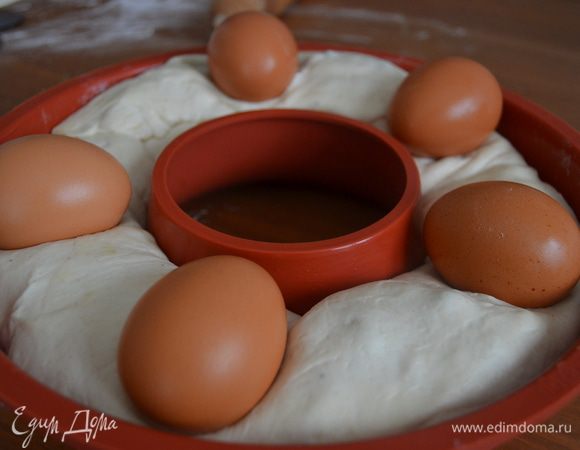 Спустя указанное время, украсить наш каравай, выложив на него вымытые яйца, слегка вдавив их в тесто.