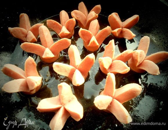 Ставим в таком виде в разогретую сковороду, плеснём ложку воды и накрываем крышкой и держим на маленьком огне! Сосиски должны раскрыться от пара, но если нет, то можно помочь раскрыть руками.