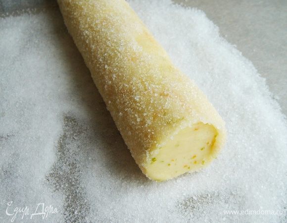 На листе пергамента смешать сахар и соль. Снять с колбасок плёнку и смазать их оставшимся желтком, а затем обвалять в сахарной смеси.