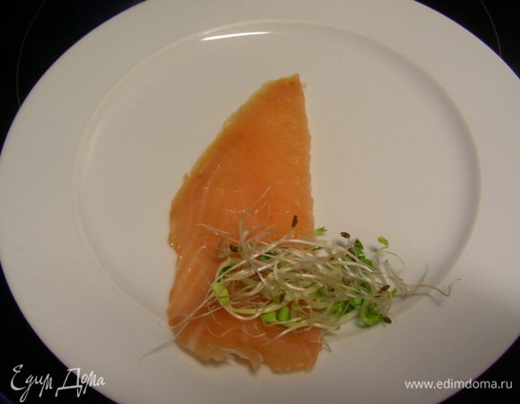 Острым ножом нарезаем кусочки копченого лосося - где-то 0.5 см толщиной, длиной около 10см и шириной 3 см. Т,е. чтобы они хорошо скручивались в роллы и не были слишком высокими. У меня была уже готовая нарезка, поэтому таких размеров не получилось, делала на глаз. Еще в журнале советуют убрать филе на 30 минут в морозилку, после чего его будет легче нарезать. У меня на фото он уже сразу и следующий шаг - на один конец выкладываем немного проростков.
