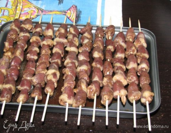 Спустя 40-60 минут сердечки из соуса изъять, соус вылить в глубокую форму для запекания (я в этой форме обычно пеку запеканки). Нанизать на шпажки сердечки. Шпажки с сердечками аккуратно уложить на бортики формы. Таким образом, соус будет кипеть в форме и обдавать своим ароматным паром наши сердечки.