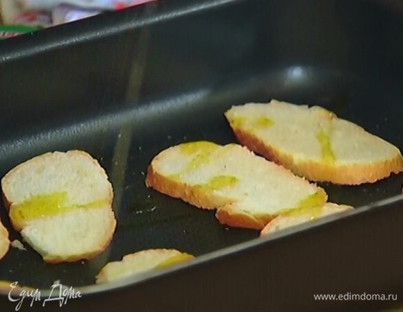 Багет тонко порезать, поместить в небольшой противень, слегка сбрызнуть оливковым маслом и отправить в разогретую духовку на 5 минут.