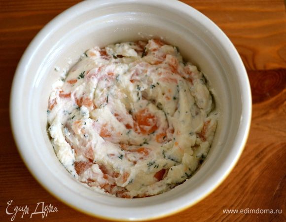 Формочки-кокотницы смазать сливочным маслом и выложить в них рыбно-сырную смесь. В центре с помощью ложки сделать небольшие углубления.