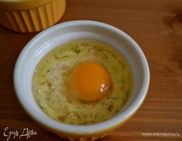 В центр каждой кокотницы осторожно выложить по яйцу, стараясь на разбить желток. Слегка посолить (по желанию).