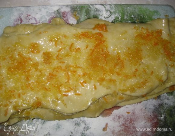 Разрезаем тесто поперек на 5 полосок. Берем одну полоску (маслом наверх), посыпаем ее 1/4 частью цедры, накрываем второй полосой, опять посыпаем цедрой и так поступаем со всеми полосками. Последнюю полоску тоже кладем маслом наверх.