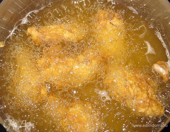 Масло влейте в глубокую кастрюлю и хорошо разогрейте. Опустите крылышки в масло по 5 штук. Обжаривайте до коричневого цвета. Подавайте с соусами.