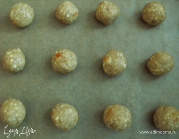  Духовку разогреваем на 180С. Делаем из теста шарики и выкладываем печенье на противень, застеленный пекарской бумагой. Расстояние между печеньем должно быть не меньше 2 см - оно довольно сильно увеличится в размере.