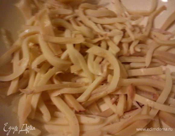 Закипятить воду, залить ею чернослив и кальмары. Кальмары сразу же обдать холодной водой, чтобы смыть свернувшуюся кожу. Отварить 2-3 минуты в подсоленой воде. Дать слегка остыть и нарезать