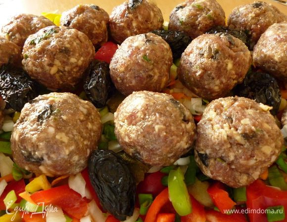 Из фарша формуем шарики и выкладываем на овощи.Я еще между шариками добавила несколько штук чернослива.