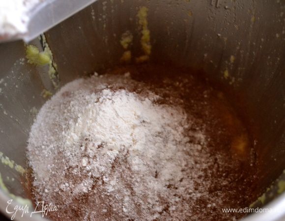 В отдельной миске смешать сухие ингредиенты: просеянную муку, какао-порошек, сахар и разрыхлитель. Всыпать сухие ингредиенты к жидкой смеси и еще раз взбить в миксере (или перемешать все тщательно вручную).