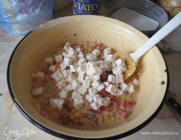 С кукурузы слить жидкость. зелень мелко нарезать,твёрдый сыр натереть на крупной тёрке. И смешать все подготовленные ингредиенты с тестом. Старайтесь, чтобы фета осталась кусочками, а не размешалась с тестом.