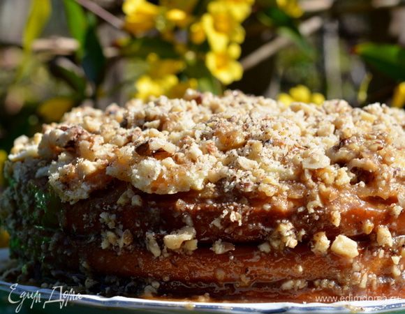 Полить торт глазурью распределяя и по бокам. Выложить орехи также по бокам. Поставить в холодильник.