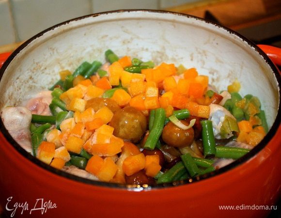 Добавить к курице грибы, порезанную на кусочки тыкву и фасоль. Посолить, поперчить и, пока готовится тесто, потушить маленьком огне. 