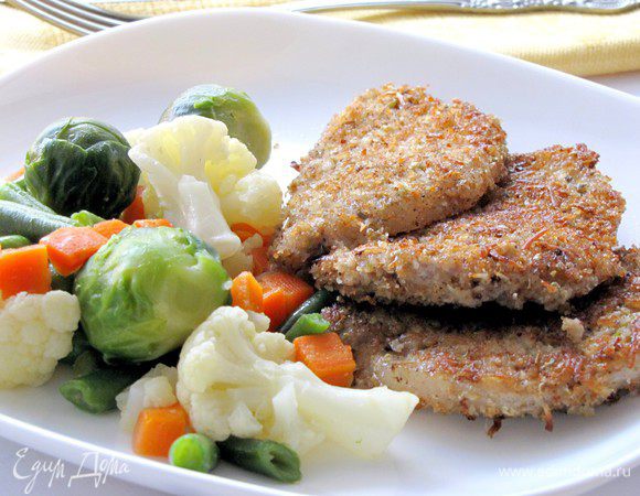 Выложите на тарелку горячие отбивные, гарнируйте их овощамии. Приятного аппетита! 