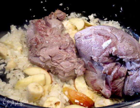 В жаровне разогреваем подсолнечное масло и обжариваем промытое в холодной воде, обсушенное и посоленное мясо ягненка со всех сторон около 5 минут. Добавляем дольки яблок (не сбрызнутые лимонным соком) и кусочки банана, лук и чеснок. Тушим еще 5 минут.