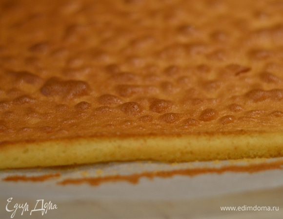 Готовый бисквит вместе с пергаментом переложить на полотенце.