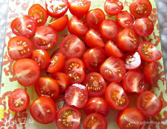Тем временем помидоры черри помыть и разрезать на половинки.