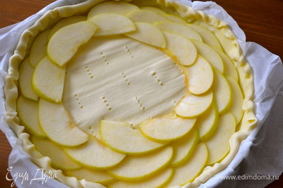 Уложить дольки яблок на тесто по спирали, немного внахлест, начиная с внешнего края торта....
