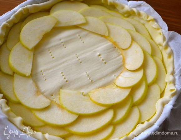 Уложить дольки яблок на тесто по спирали, немного внахлест, начиная с внешнего края торта.... 
