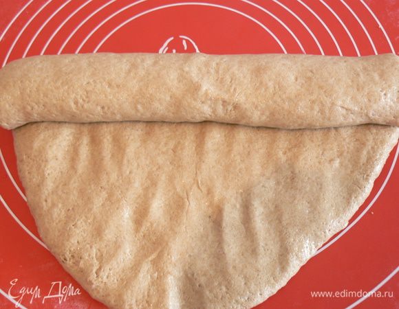 Выброженное тесто выложить,расплющить его и свернуть в плотный рулет