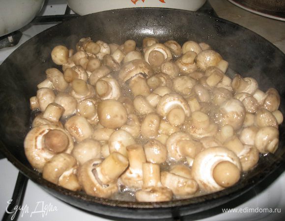 Шампиньоны моем, кладем на сковороду, смазанную растительным маслом, и накрываем крышкой, оставляем на то время, пока не выпарится вся лишняя вода, иногда перемешивая.
