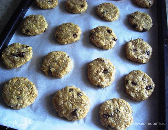 Овсяно-кокосовые шарики придавить  с вилкой или просто пальцами и разложить их на противень, имея в виду, что они еще будут чуть-чуть увеличиваться.