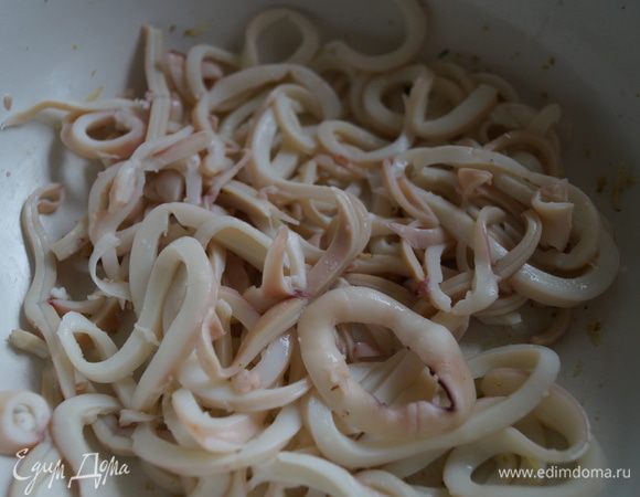 Остывшие кальмары нарезать тоненькими колечками, выложить в чашку