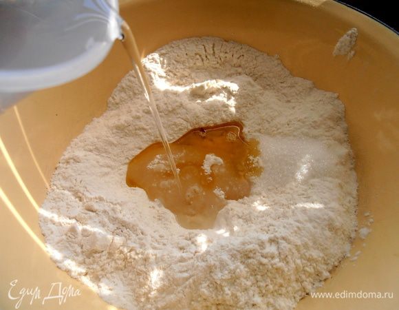 Вливаем воду комнатной температуры и замешиваем тесто минут 5-7.