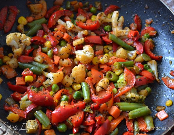 Болгарский перец нарезать кубиками. В сковороде хорошо разогреть растительное масло. Выложить замороженные овощи, не размораживая их и болгарский перец. Посолить, поперчить, добавить специи и травы на ваш вкус и жарить до готовности.