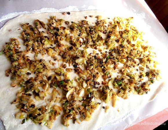 У меня раскаталось в пласт размером 54/37 см...Выкладываем равномерно всю начинку.