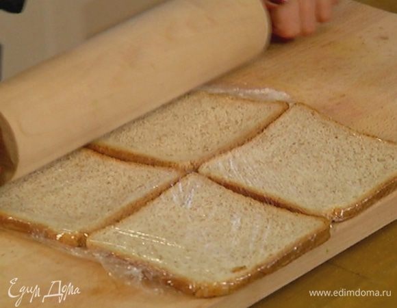 Хлеб поместить между слоями пищевой пленки и раскатать скалкой.