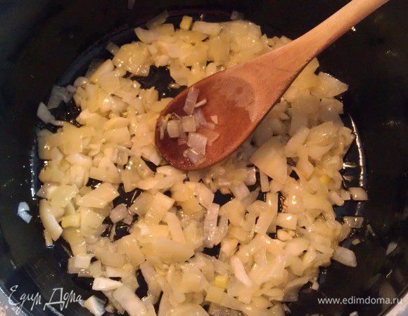 В кастрюле с толстым дном обжарить на оливковом масле мелко нарезанный лук и чеснок до прозрачности.