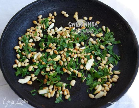 Духовку разогреваем до 180С. На сухой чистой сковороде обжариваем кедровые орешки, когда они начнут золотиться, кладём к ним нарезанный пластинками чеснок и измельчённую петрушку. Обжариваем всё вместе, помешивая.