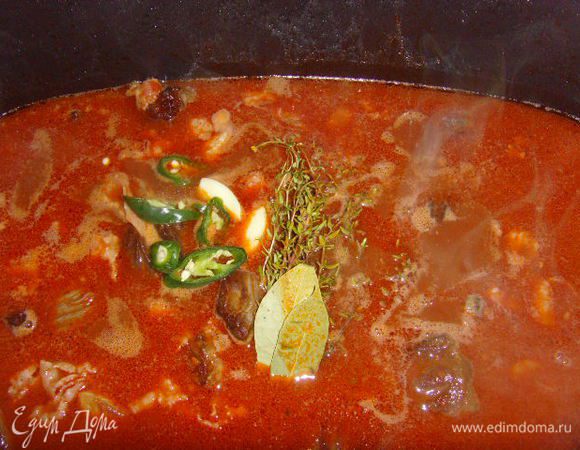 Залить бульоном (у меня говяжий, но подойдёт и куриный), вином, добавить чеснок и лавровый лист, а так же тимьян. Тут я не удержалась и добавила пару колечек чили перца, хотя в рецепте этого нет.  Далее мясо томить в духовке при температуре 180° около 1,5 часов.