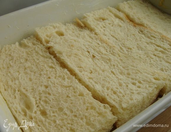 Форму для запекания смазать сливочным маслом. Я использую батон. Разрезать куски батона вдоль и плотно уложить в форму.