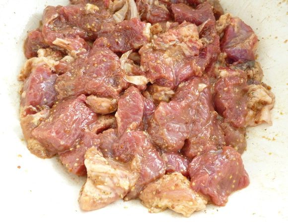 Мясо нарезать небольшими кусочками,добавить горчицу,соевый соус,виноградный уксус,смесь хмели-сунели,оливковое масло,все хорошо перемешать,накрыть крышкой посуду с мясом и оставить мариноваться на 1 час.