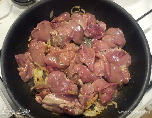 Печень разрезать на дольки и добавить к луку. Обжарить по 3 минуты с каждой стороны. Влить коньяк и выпарить.