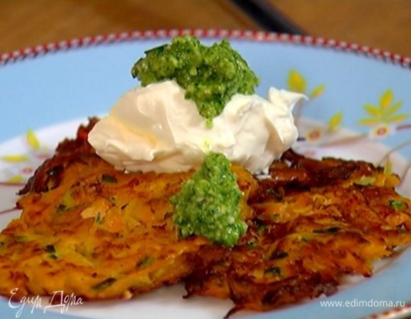 Приготовить соус песто: зеленый перец чили порезать небольшими кусочками. Соединить орехи, листья петрушки и кинзы, зеленый лук, влить кунжутное и оливковое масло и взбить все в блендере. 
Подавать оладьи со сметаной и соусом песто.
