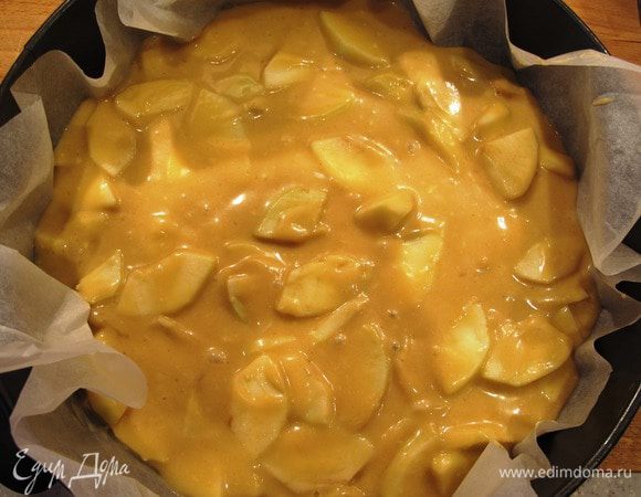 Разъемную форму застелить бумагой для выпечки, влить тесто с яблоками, разровнять. Выпекать в духовке до образования румяной корочки минут 40.
