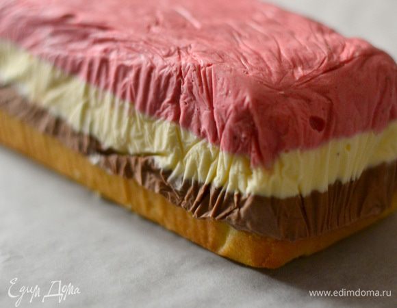 Кладем корж на пергамент, на него выкладываем готовое мороженое.