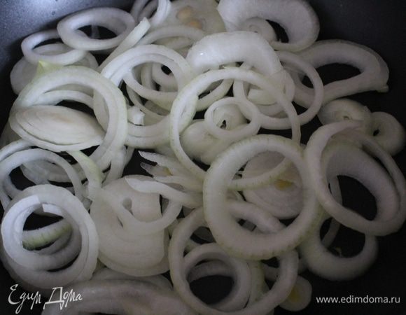 Лук нарезать кольцами и выложить в сковороду, смазанную маслом.