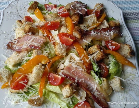 Достаем из духовки гренки и индейку и выкладываем в произвольном количестве сверху листьев. Бекон можно оставить полосками, а можно поламать на кусочки. Выкладываем несколько полосок перца и украшаем разрезанными на четвертинки помидорами. Сверху посыпаем пармезаном.