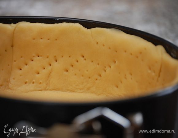 После указанного времени раскатать тесто, равномерно распределить его по форме, наколоть вилкой и убрать в морозилку на 25 минут.