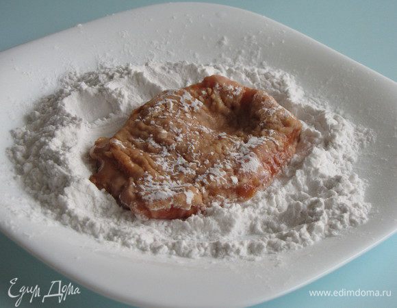 Достаньте отбивные из маринада и обваляйте в крахмале.