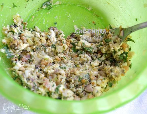 Разогреваем духовку до 200С. Отварные морепродукты нарезаем и вместе с измельчённой зеленью добавляем к начинке. Всё хорошо разминаем.